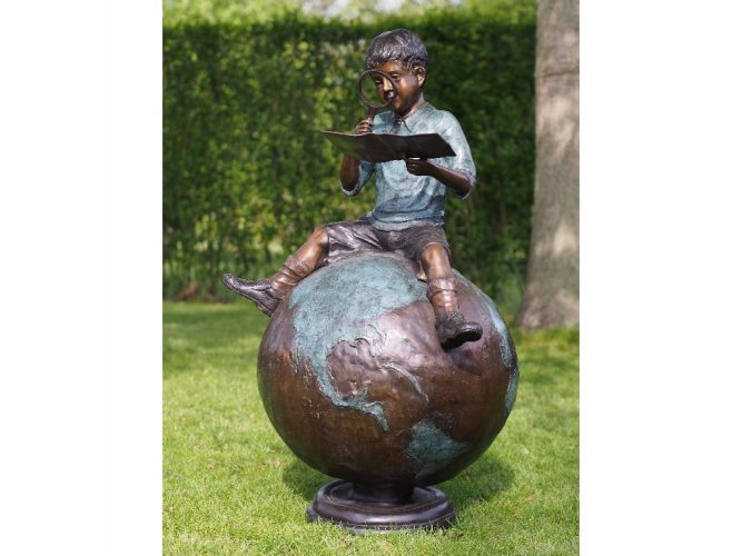 jongen met boek op wereldbol
